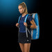 Model mit OLIVER Sportkleidung und OLIVER Gearbag Extend in blau, grau und schwarzer Farbe auf dunklem Hintergrund.