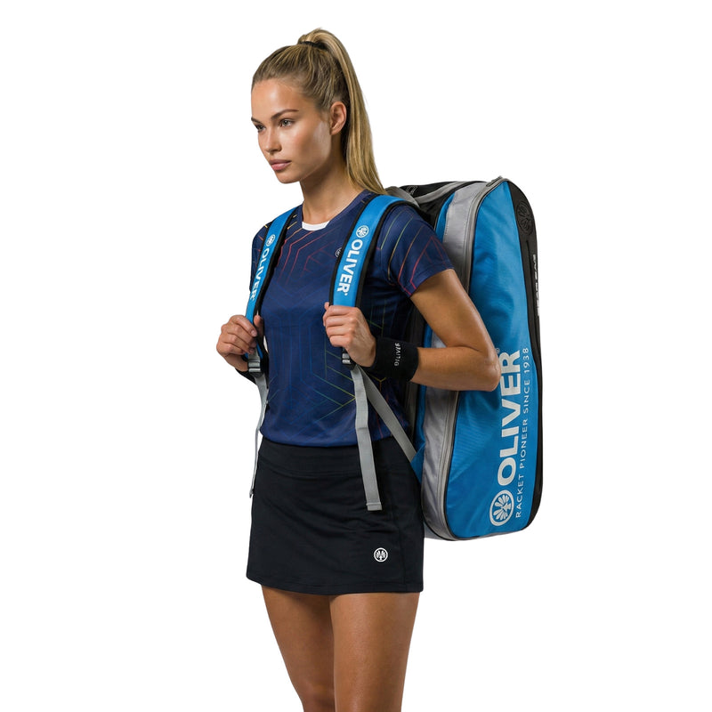 Model mit OLIVER Sportkleidung und OLIVER Gearbag Extend in blau, grau und schwarzer Farbe auf weißem Hintergrund.