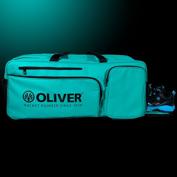 OLIVER Rackettasche EXTEND in türkisgrün mit geöffnetem Schuhfach und Schuhen von OLIVER auf dunklem Hintergrund.